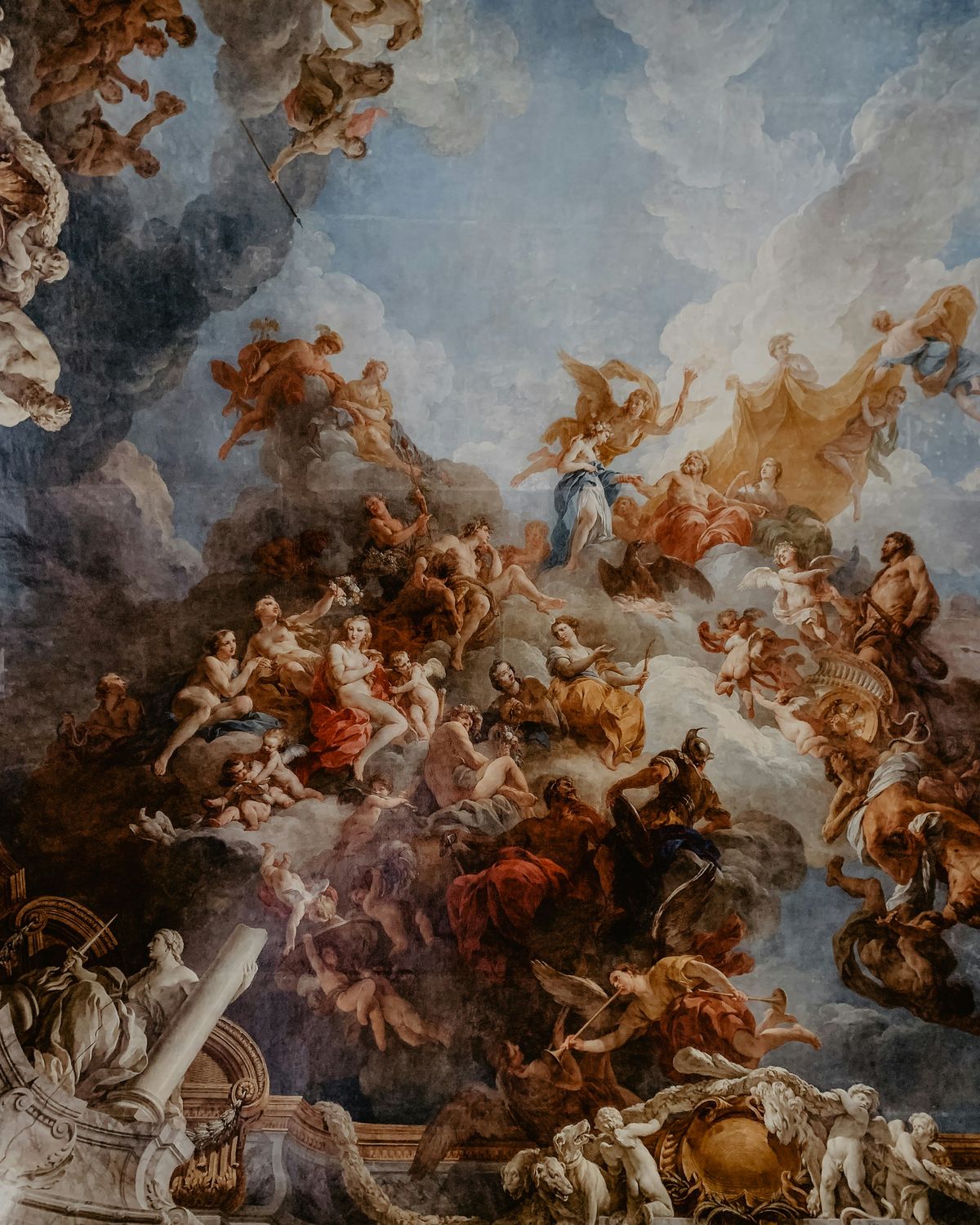 This painting is a dramatic ceiling fresco featuring mythological figures, angels, and warriors in a dynamic composition. The figures are surrounded by clouds, with vibrant colors and intricate details, typical of Baroque or Renaissance art.
